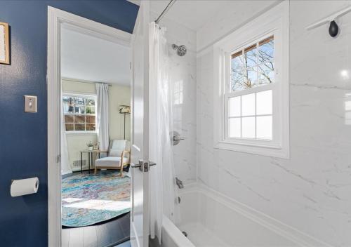 a white bathroom with a shower and a window at Capital Oasis - Family Friendly & Centrally Located - Mins to DC Smithsonians and Top Spots in Alexandria