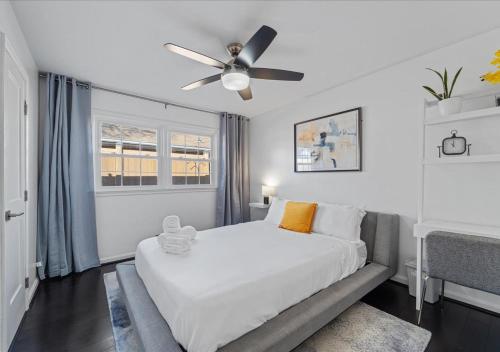 a white bedroom with a bed and a ceiling fan at Capital Oasis - Family Friendly & Centrally Located - Mins to DC Smithsonians and Top Spots in Alexandria