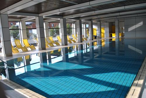 a swimming pool with yellow chairs in a building at Ferienwohnung Pichlarn in Aigen im Ennstal