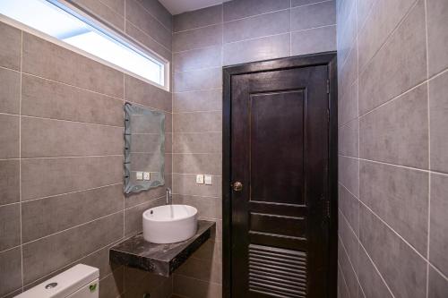 a bathroom with a toilet and a sink and a door at 1 BR Serviced Apt In The Heart of Siem Reap in Siem Reap