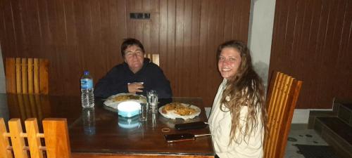 Ein Mann und eine Frau sitzen an einem Tisch mit Essen in der Unterkunft Dedunu Guest in Badulla