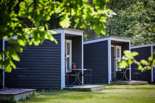a black house with chairs and a table in the yard at UKI Puhkeküla in Ranna