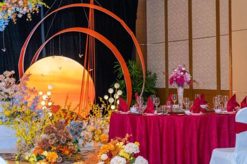 a table with glasses on it with flowers on it at Marco Polo Xiamen in Xiamen