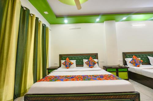 a bedroom with a large bed with colorful pillows at FabHotel Kempty Lake Resort in Mussoorie