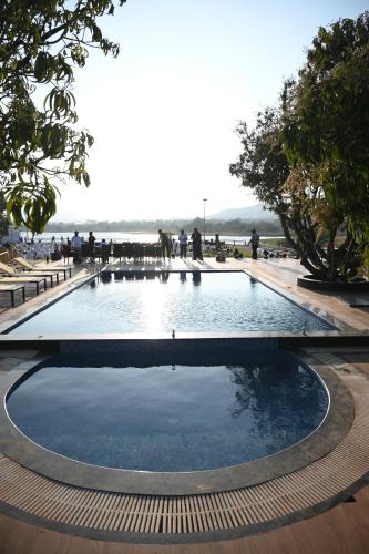 a large pool of water with people standing around it at Mango Leaf Lake Resort in Pune