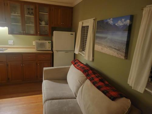 a living room with a couch and a refrigerator at Riverbend Guest House in Chilliwack