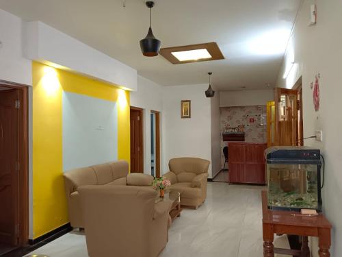 a living room with two couches and a fish tank at SAVIS home stay in Ooty