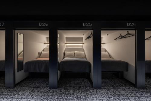 a bedroom with two beds and two mirrors at The Millennials Fukuoka in Fukuoka