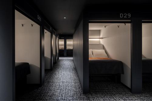 um pequeno quarto com 2 camas e um corredor em The Millennials Fukuoka em Fukuoka