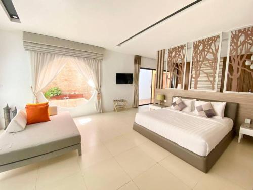 a large bedroom with a bed and a couch at Cae Villa Hua Hin in Hua Hin