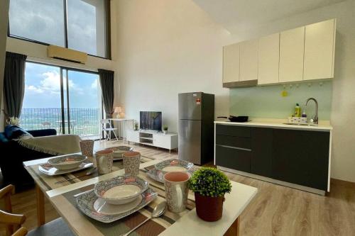 a kitchen and living room with a table with dishes on it at E2 Emporis KD Sunway Gize SOHO in Petaling Jaya