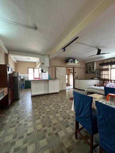 a large kitchen with a table and blue chairs at Lilen's Homestay - Casa Verde in Kathmandu