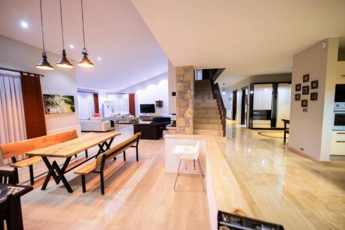 a large living room with a table and benches at Villa Queen Palm in Kumluca