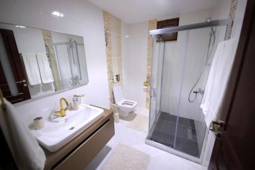 a bathroom with a sink and a shower and a toilet at Villa Queen Palm in Kumluca