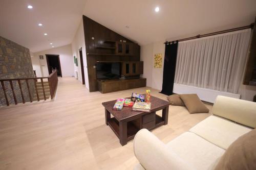 a living room with a couch and a coffee table at Villa Queen Palm in Kumluca