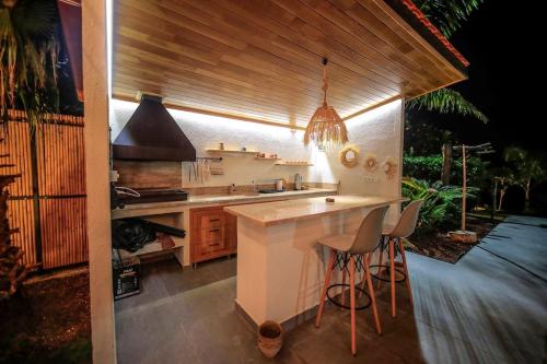 a kitchen with a stove and a counter with stools at Villa Queen Palm in Kumluca