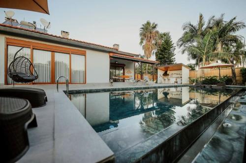 a swimming pool in front of a house at Villa Queen Palm in Kumluca