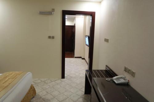 a room with a bed and a phone on a table at فندق جوافة اللوتس in Najran