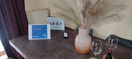 a table with a vase and two wine glasses on it at Lucy's apartment in Athens