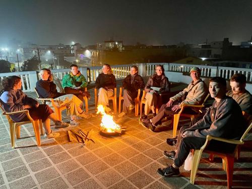 a group of people sitting around a fire at GARG COMPLEX GUESTHOUSE in Bharatpur