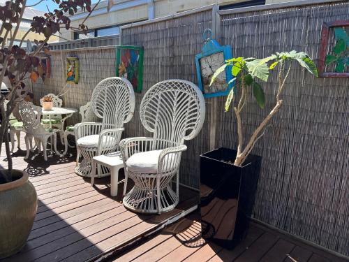 a group of white chairs and tables on a deck at Whitfords Retreat - 2 Bedroom unit in Perth