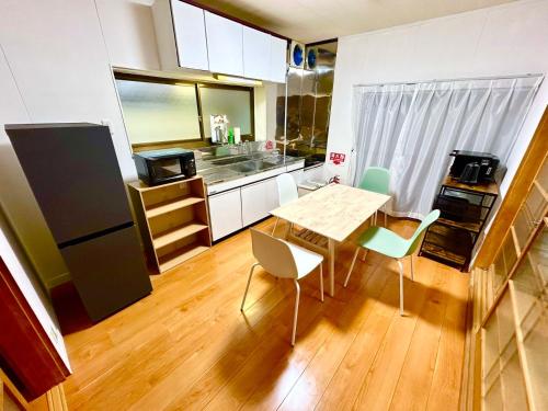 uma cozinha com mesa e cadeiras num quarto em ゲストハウス 畔（hotori） 