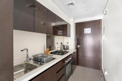 a kitchen with a sink and a stove top oven at Lovely Studio in Business Bay in Dubai