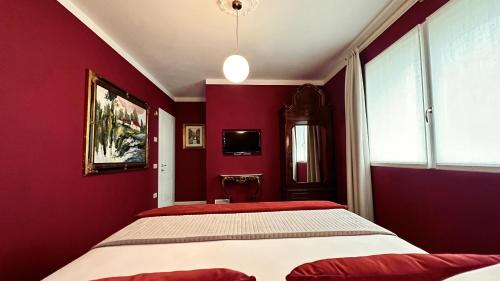 una camera con pareti rosse e un grande letto di Villa Danilla a Salzano