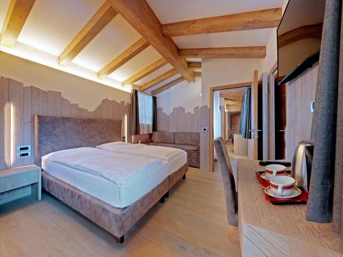 a bedroom with a large bed and a television at Hotel Madonna delle Nevi in Folgarida