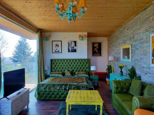 sypialnia z zielonym łóżkiem i kanapą w obiekcie Fairmont cottage Mukteshwar w mieście Mukteshwar