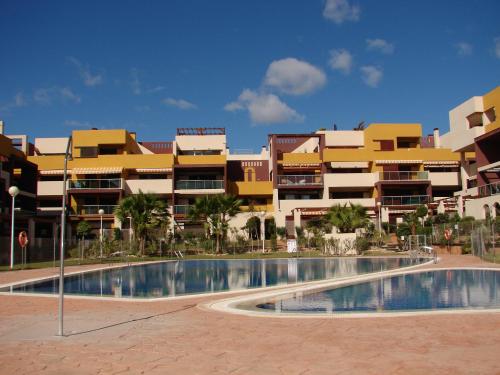 a large apartment complex with a swimming pool in front of a building at Apartamento en Playa Flamenca (residencial El Bosque) in Playas de Orihuela