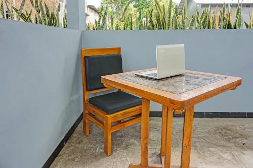 a wooden desk with a laptop computer on it at Hotel O Juanda Homestay Syariah in Pasuruan