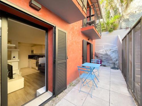 une terrasse avec une table bleue et des chaises. dans l'établissement Le caroubier, à Beausoleil