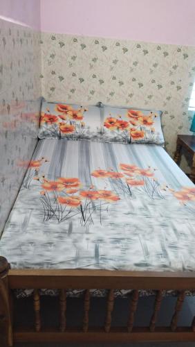 a bed with orange fish drawings on it at Happy Tourist Home and Dormitory Neyyardam in Parattipalli