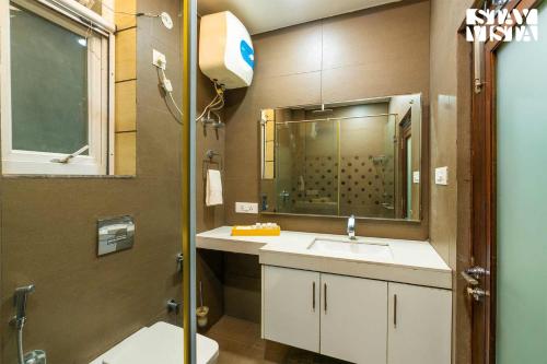 a bathroom with a sink and a mirror at StayVista at Address By The Khul in Dharamshala