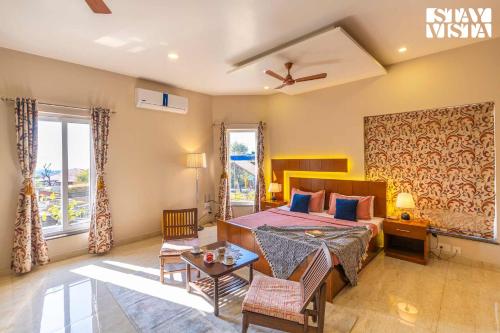 a bedroom with a bed and a living room at StayVista at Address By The Khul in Dharamshala
