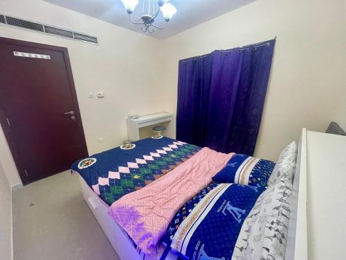 a bedroom with a bed with a purple curtain at Deira Salahuddin Comfort Residences in Dubai