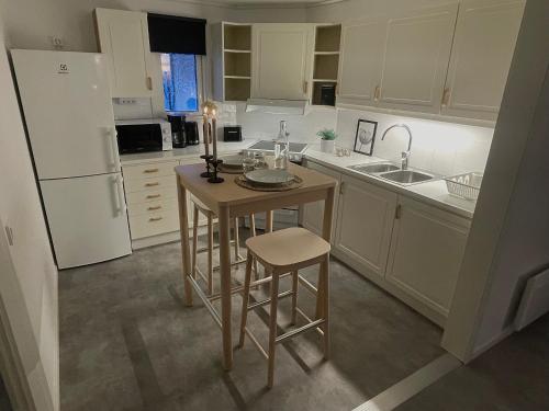 a kitchen with a small table and a refrigerator at Frost Longstay Lombiavägen in Kiruna