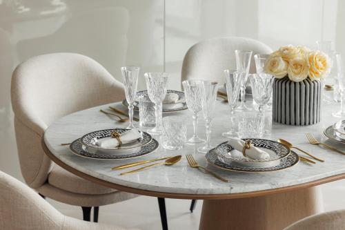 a table with plates and glasses and a vase on it at One&Only One Za'abeel in Dubai