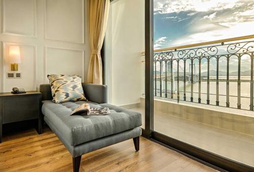 a living room with a chair and a large window at Luxury Ocean View Danang Golden Bay in Danang