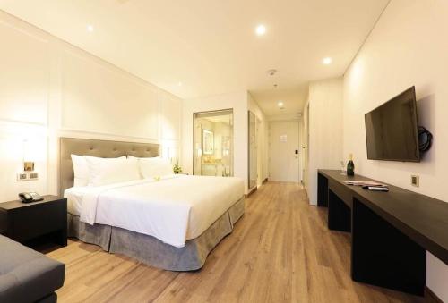 a hotel room with a large bed and a flat screen tv at Luxury Ocean View Danang Golden Bay in Danang