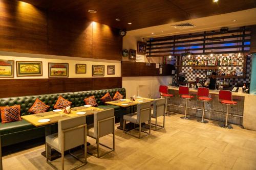 a restaurant with tables and chairs and a bar at Ramada Ajmer in Kishangarh