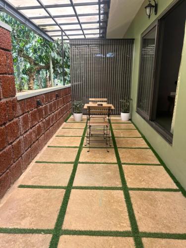 a patio with a table and chairs on a brick wall at SylVan Resort in Wayanad