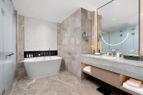 a bathroom with a tub and a sink at Holiday Inn Quanzhou Donghai by IHG in Quanzhou