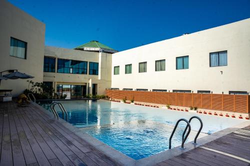 a swimming pool in front of a building at Ramada Ajmer in Kishangarh