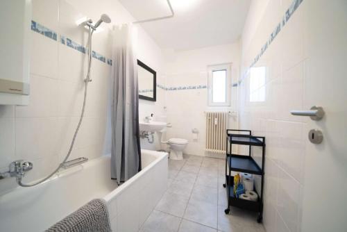 a bathroom with a shower and a tub and a sink at DWK: Monteurwohnung Koblenz in Koblenz