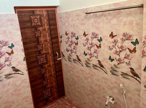 a bathroom with butterflies and flowers on the wall at J&B Homestay in Dibrugarh