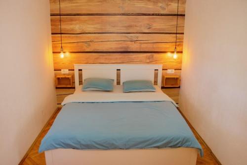 a bedroom with a bed with two blue pillows at Apartment Iskra in Njivice