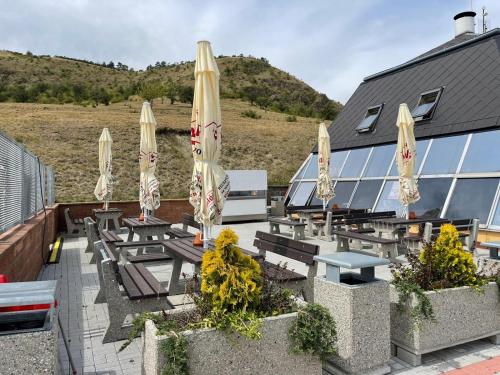 a patio with tables and umbrellas on a building at Ubytování Skleník in Raná