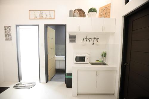 a small kitchen with a sink and a microwave at Tierra Javier in Angeles